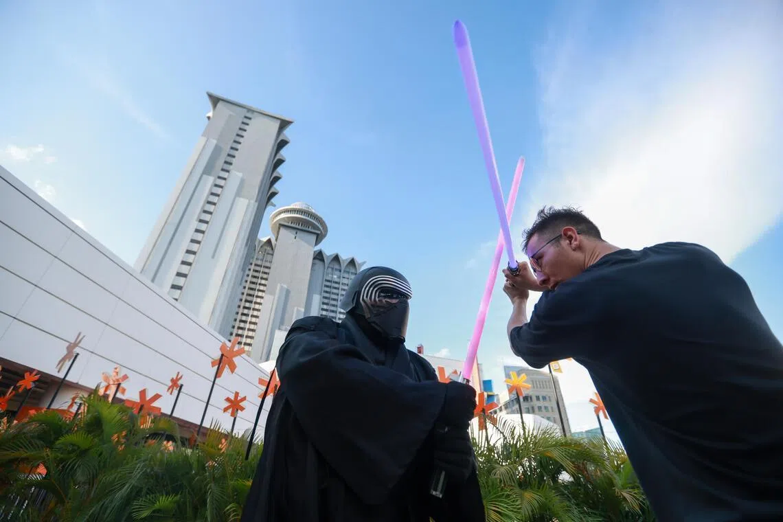Two people duelling with lightsabers at Scape.