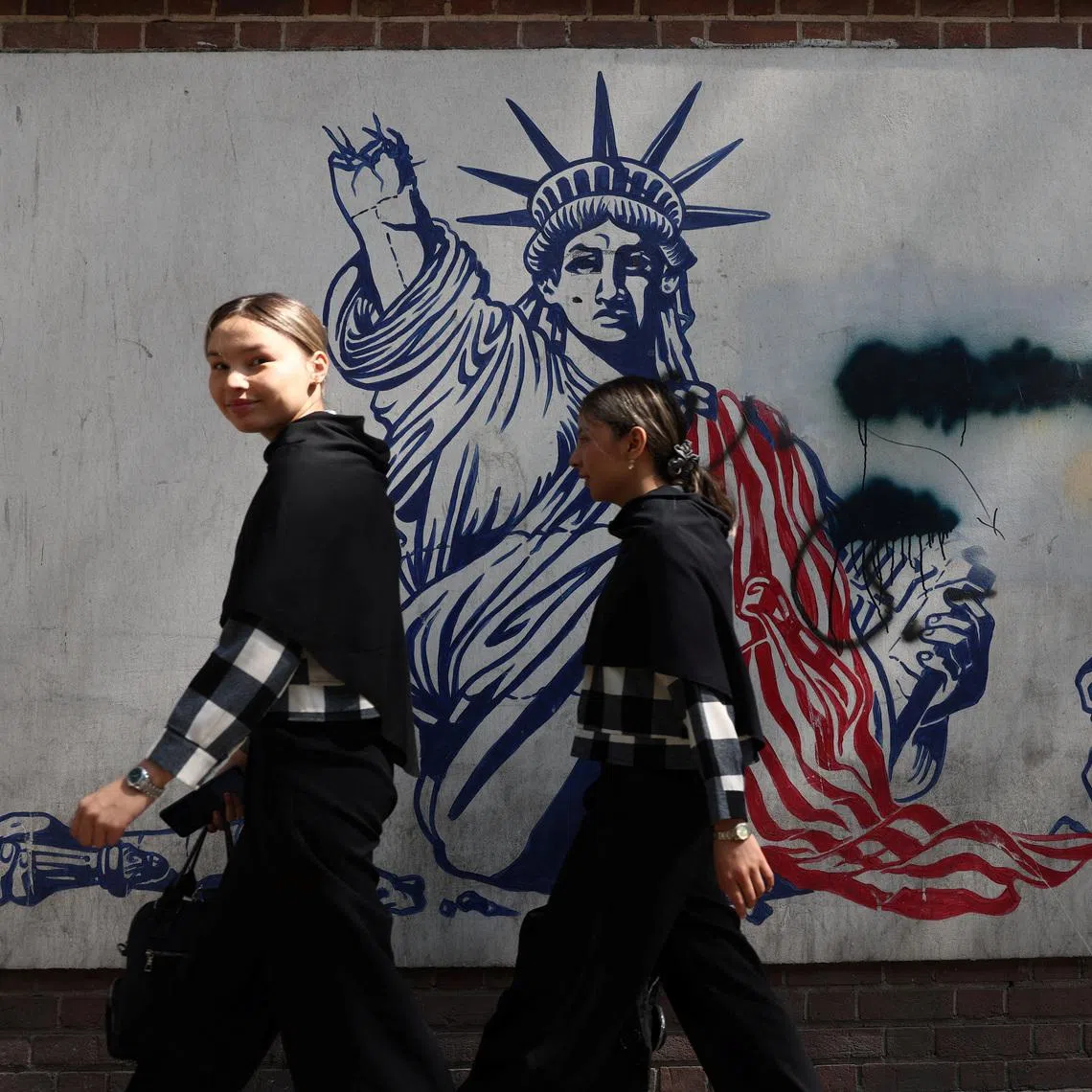 People walking near an anti-US mural in Tehran, Iran, on June 30.