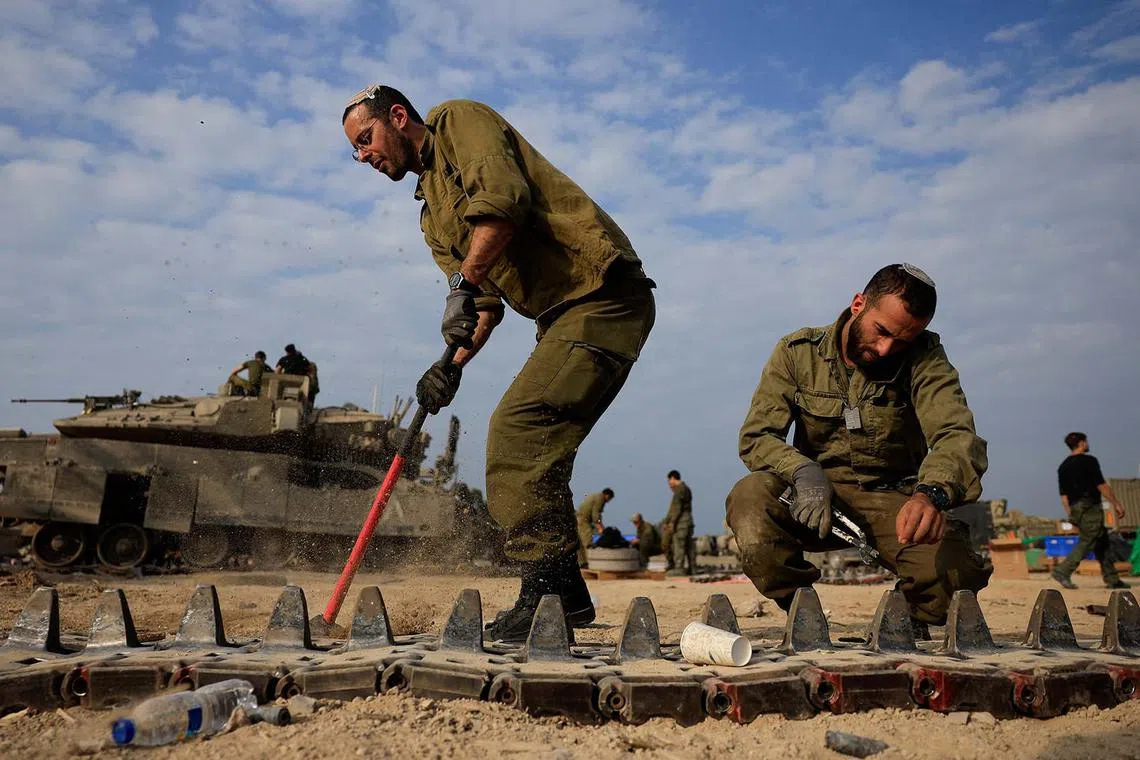 Israeli soldiers working to repair tanks amid the ongoing conflict between Israel and the Palestinian Islamist group Hamas, near the Israel-Gaza border, in southern Israel, Dec 28, 2023. 