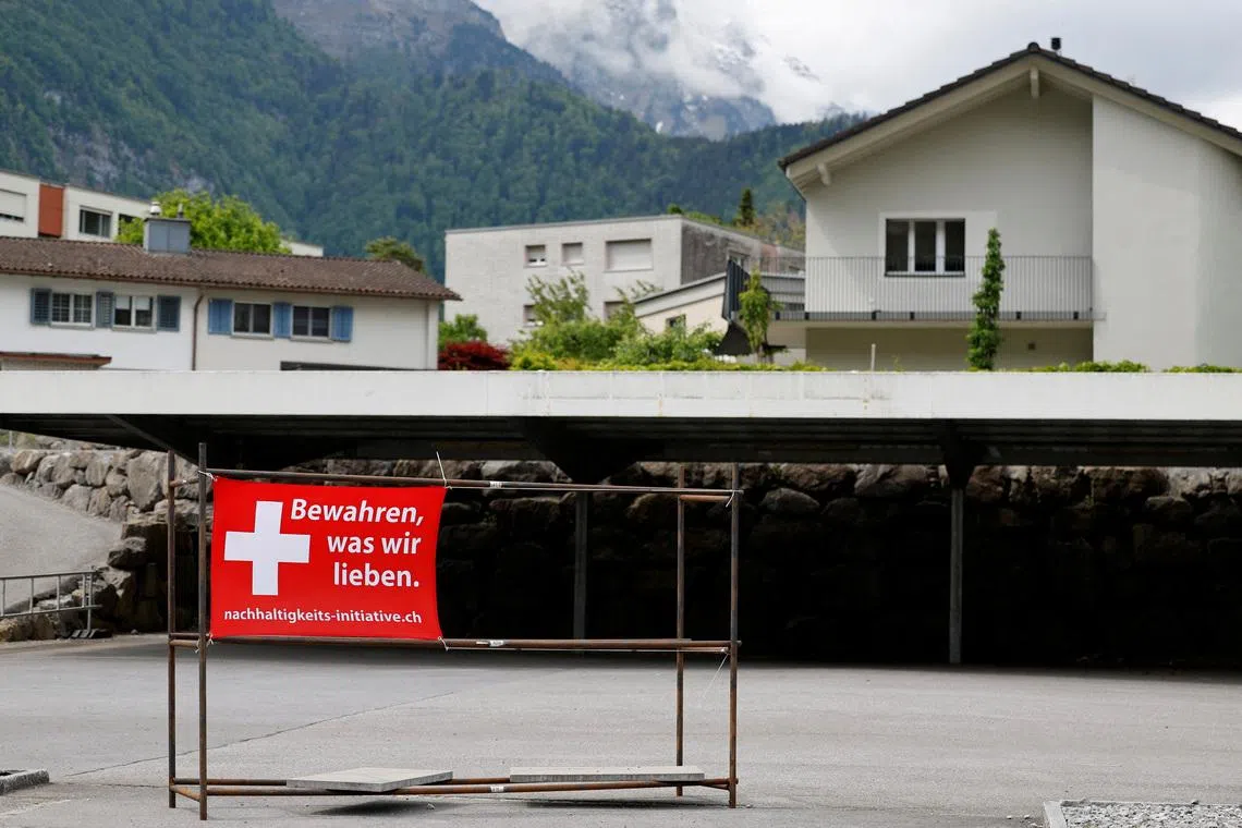 A sign is pictured ahead of a June 14 vote on a plan backed by the right-wing Swiss People's Party (SVP) to cap the population at 10 million inhabitants, in Glarus, Switzerland, May 18, 2026. The sign reads: \"Preserve what we love\". REUTERS/Stefan Wermuth