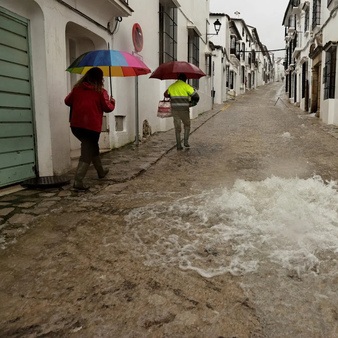 People walk along a flooded street due to heavy rains, as storm Leonardo hits parts of Spain, in Grazalema, Spain, February 5, 2026. REUTERS/Jon Nazca
