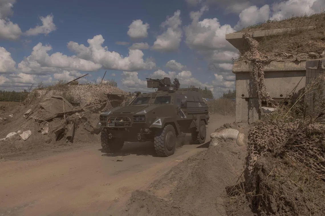A Ukrainian military vehicle driving past a destroyed border crossing point with Russia, in the Sumy region, on Aug 14.