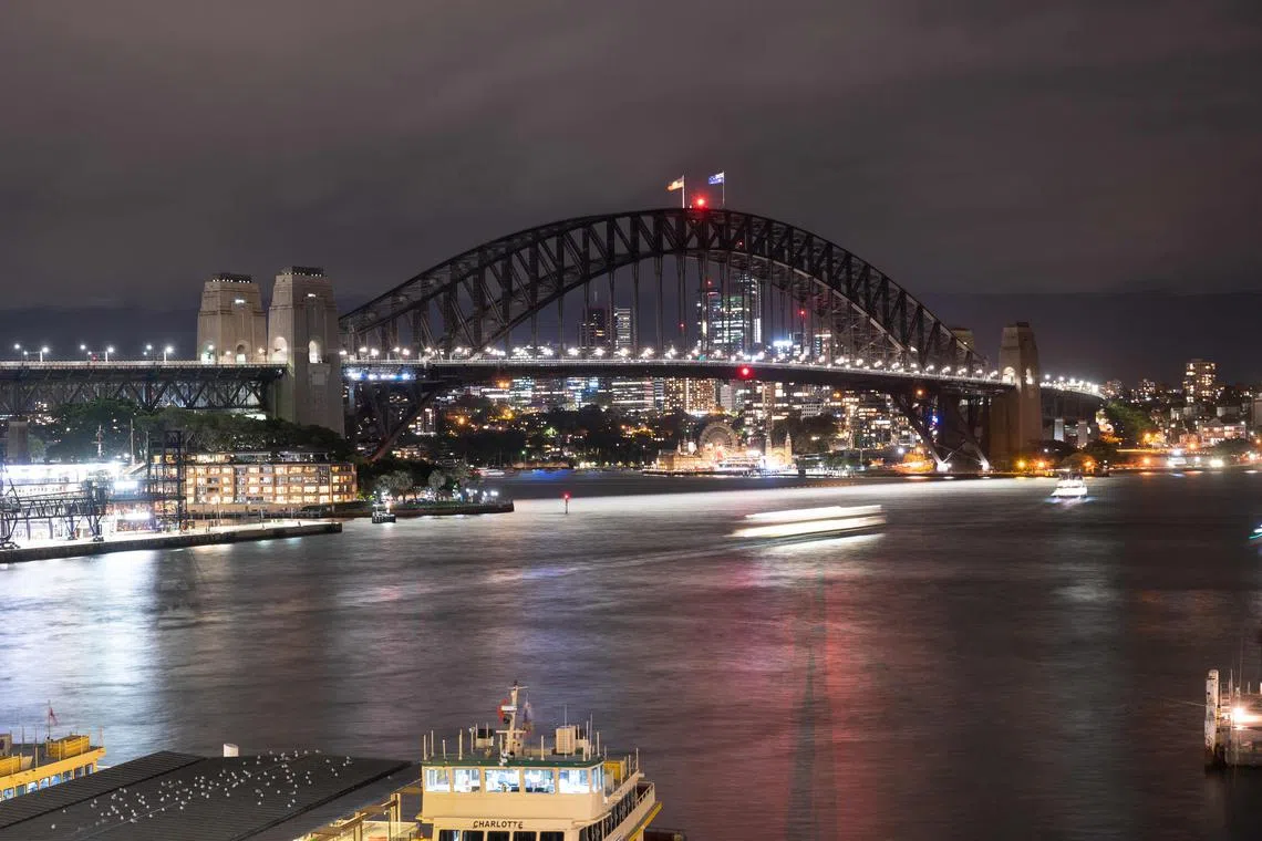 This picture shows the Sydney Harbour Bridge with its lights switched off during the Earth Hour environmental campaign in Sydney on March 25, 2023. (Photo by Wendell Teodoro / AFP)