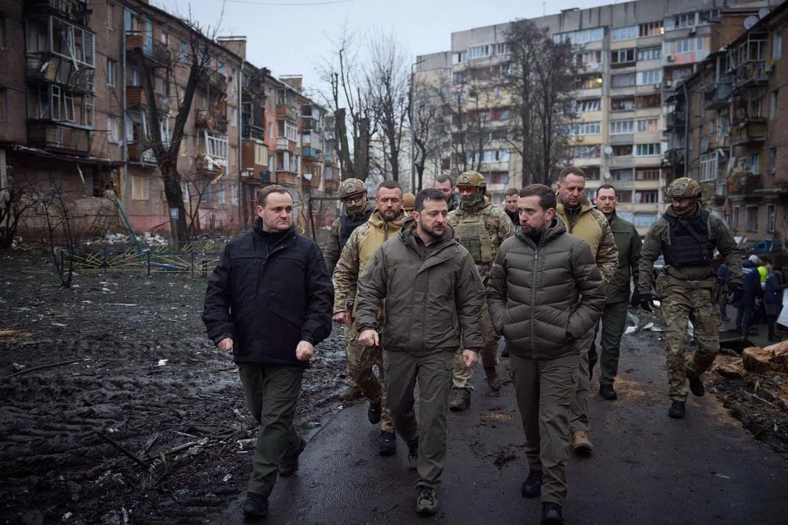 Ukraine's President Volodymyr Zelensky (centre) inspects residential buildings damaged by Russian missile attacks, in Vyshgorod, outside the capital Kyiv.