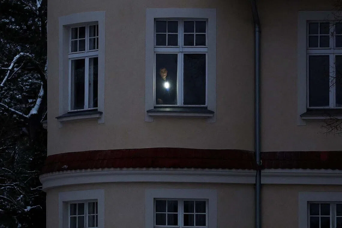 A man uses a torch in his apartment during a blackout that left thousands of homes without electricity after a suspected arson attack at the power plant Lichterfelde, in the district Steglitz-Zehlendorf, in southern Berlin, Germany, January 4, 2026. REUTERS/Lisi Niesner TPX IMAGES OF THE DAY