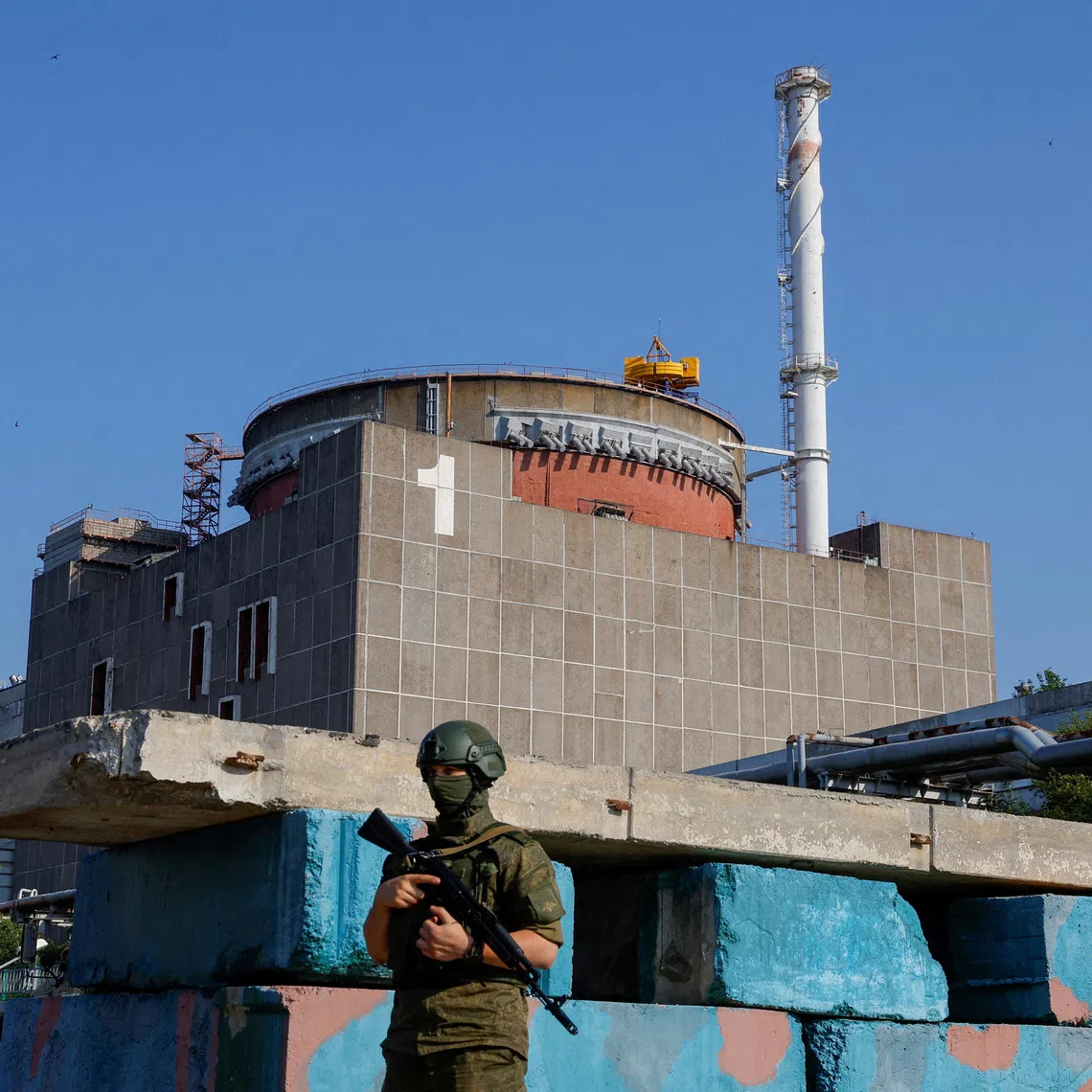 FILE PHOTO: A Russian service member stands guard at a checkpoint near the Zaporizhzhia Nuclear Power Plant before the arrival of the International Atomic Energy Agency (IAEA) expert mission in the course of Russia-Ukraine conflict outside Enerhodar in the Zaporizhzhia region, Russian-controlled Ukraine, June 15, 2023. REUTERS/Alexander Ermochenko/File Photo