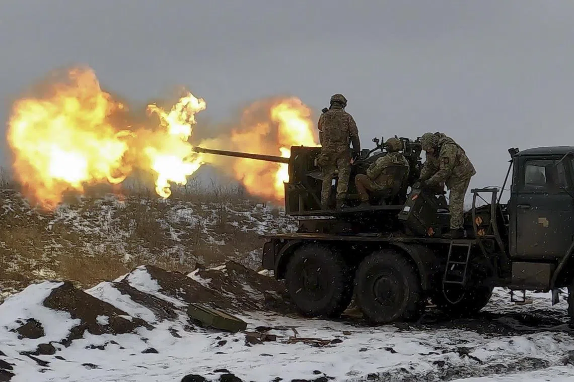 Ukrainian soldiers fire an anti-aircraft gun at a position near Bakhmut, in Ukraine's Donetsk region.