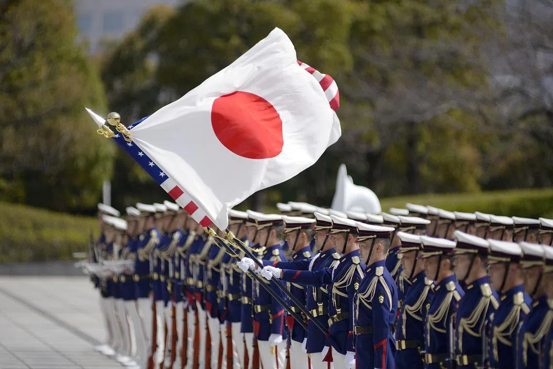 FILE PHOTO: U.S. and Japan national flags futter in the wind as Lloyd Austin, Secretary of Defense of the United States of America  and Japanese Defense Minister Kishi Nobuo attends a review an honor guard prior the US-Japan Defense Ministers Bilateral meeting at the Japan Ministry of Defense on March 16, 2021 in Tokyo, Japan.  David Mareuil/Pool via REUTERS/File Photo