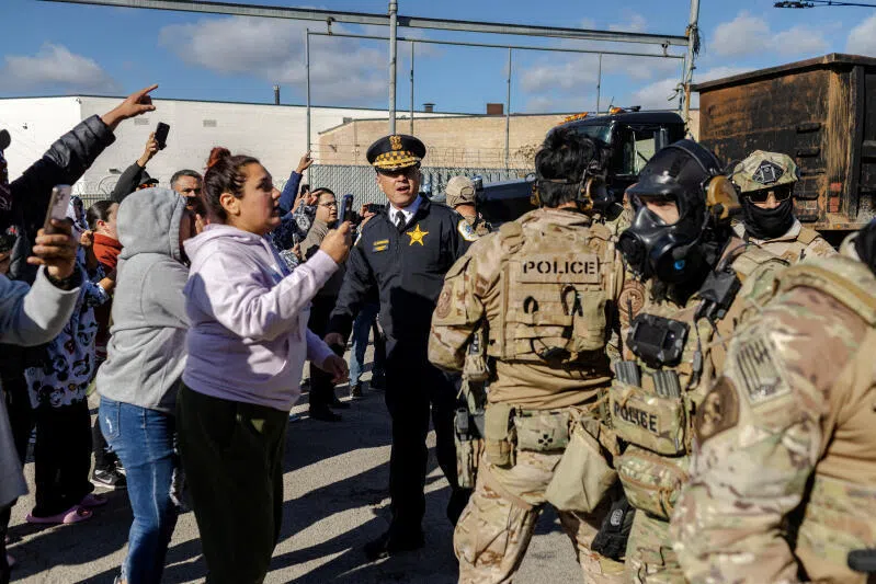 US federal agents confront community members during a standoff in Chicago, Illinois, on Oct 23.
