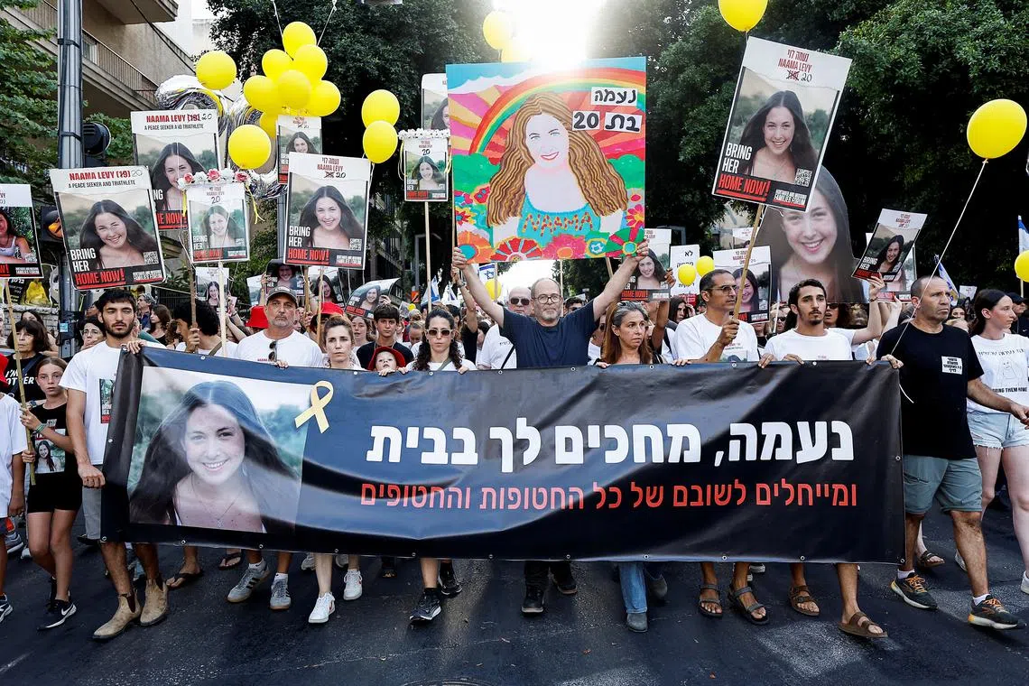 People hold a banner, as family, friends, and supporters of Israeli hostage Naama Levy, who was kidnapped during the deadly October 7 attack, attend a protest march on her 20th birthday, in Tel Aviv, Israel, June 22, 2024. REUTERS/Eloisa Lopez