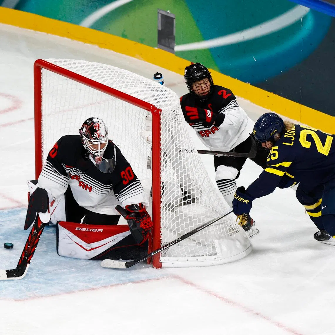 Milano Cortina 2026 Olympics - Ice Hockey - Women's Preliminary Round - Group B - Japan vs Sweden - Milano Rho Ice Hockey Arena, Milan, Italy - February 10, 2026. Lina Ljungblom of Sweden in action with Rei Halloran of Japan and Shiori Koike of Japan REUTERS/Alessandro Garofalo