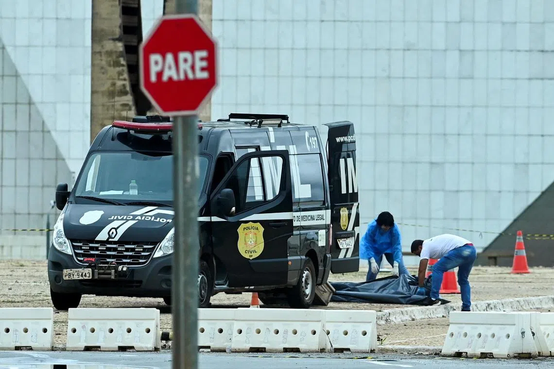 Forensic workers remove the body of a man after a suspect in a bomb attack killed himself outside the Brazilian Supreme Court building the morning after explosions in the Three Powers Square in Brasilia, Brazil November 14, 2024. REUTERS/Ton Molina