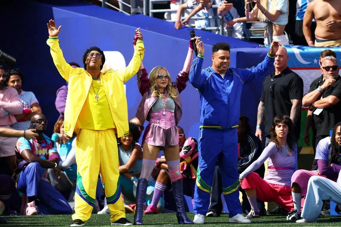 Former Brazil football players Ronaldinho (left) and Ronaldo (right) with Madonna (centre) during the World Cup final halftime show.