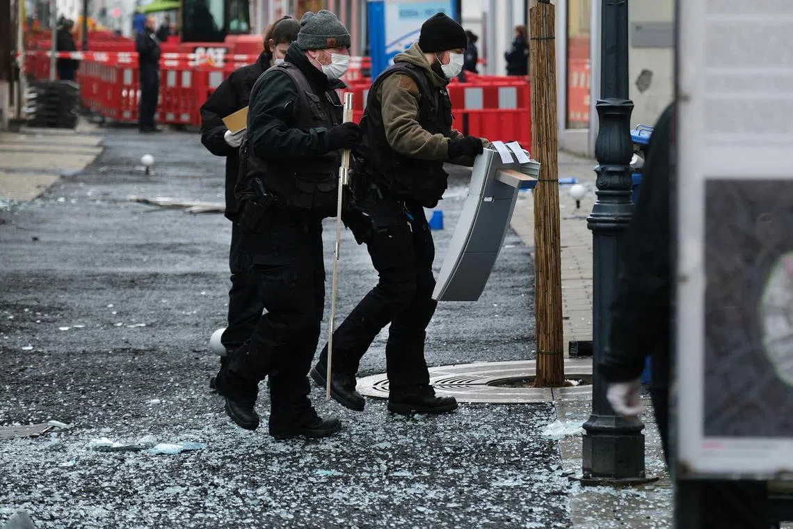 Law enforcement officers investigate the scene following an attack on bank ATMs in Ratingen, Germany, on March 15, 2023.