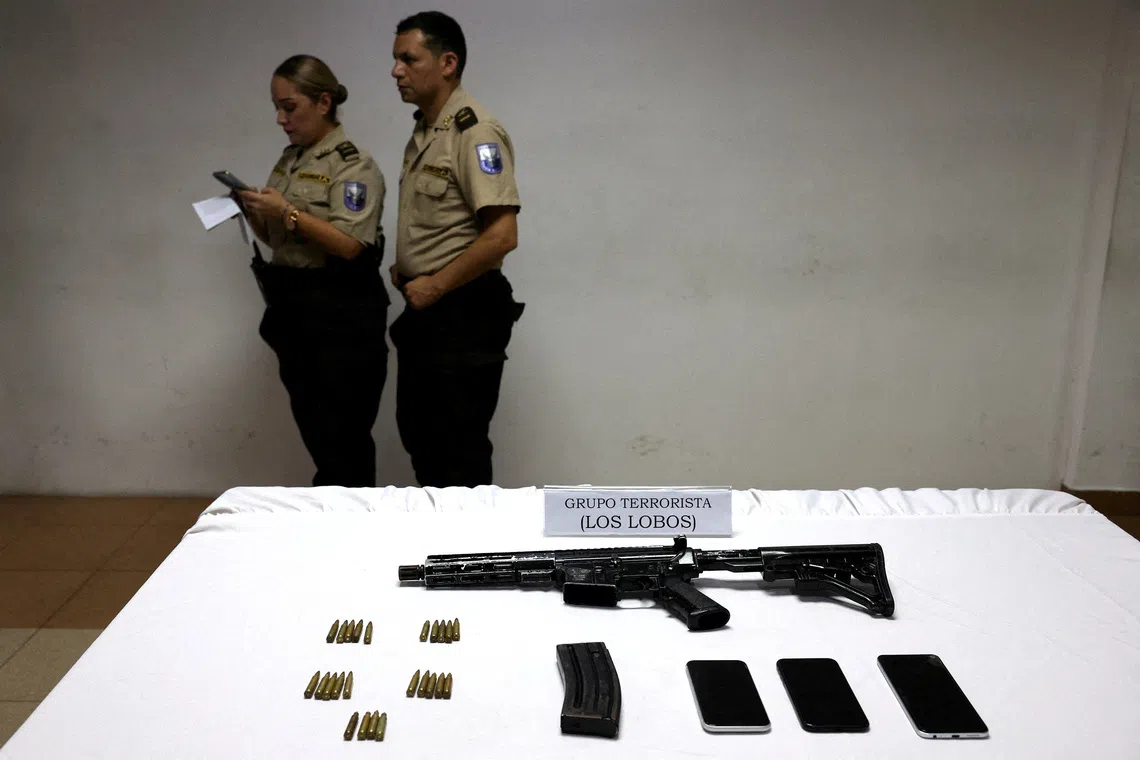 FILE PHOTO: A weapon is shown at a police station in the aftermath of a wave of violence that saw the storming of a TV station on-air and explosions around the nation, in Guayaquil, Ecuador, January 11, 2024. The sign reads 'Terrorist group Los Lobos'. REUTERS/Ivan Alvarado/File Photo