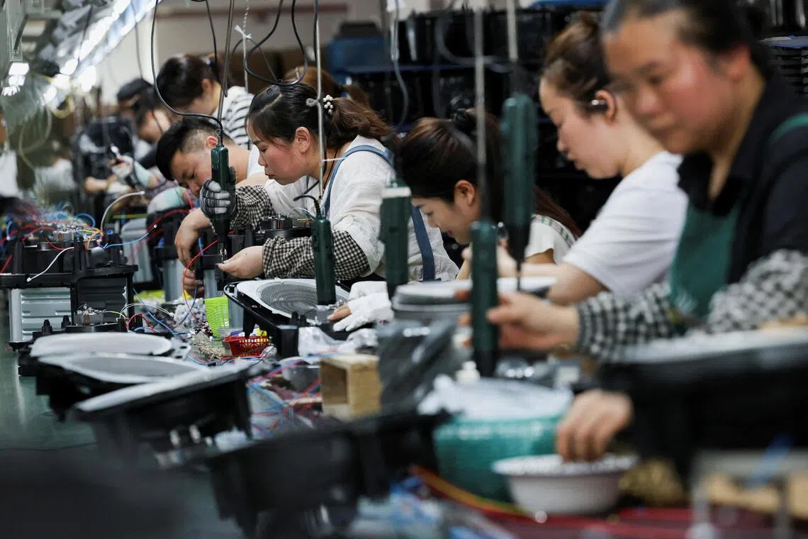 FILE PHOTO: Employees of Gstar Electronic Appliance Co., Ltd work to assemble air fryers in the factory in Ningbo, Zhejiang province, China May 19, 2025. REUTERS/Go Nakamura/File Photo
