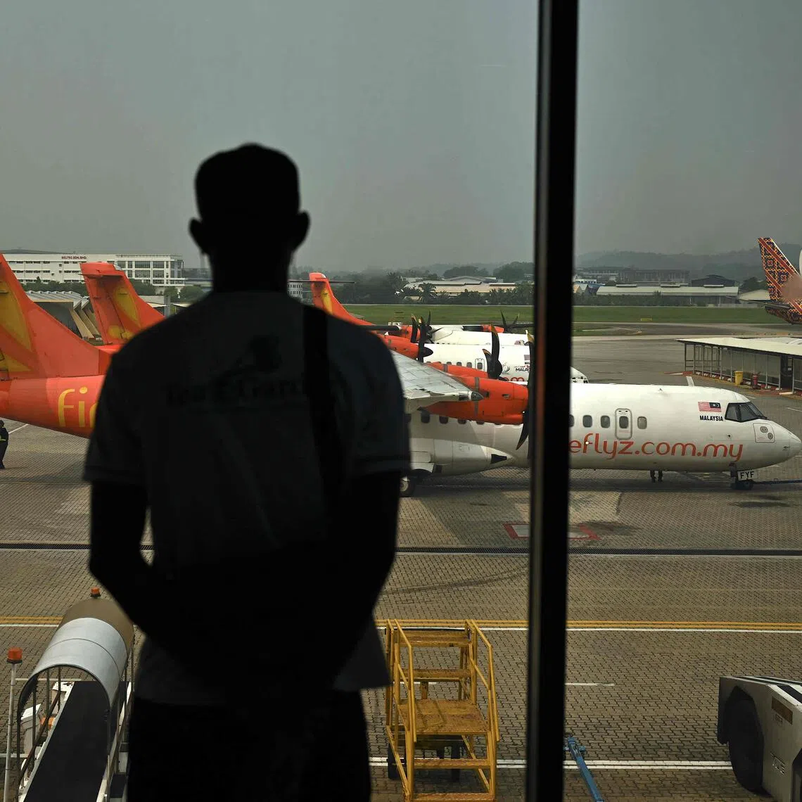 A passenger looking at Firefly aircraft parked on the tarmac at Sultan Abdul Aziz Shah Airport in Subang, on Oct 13.