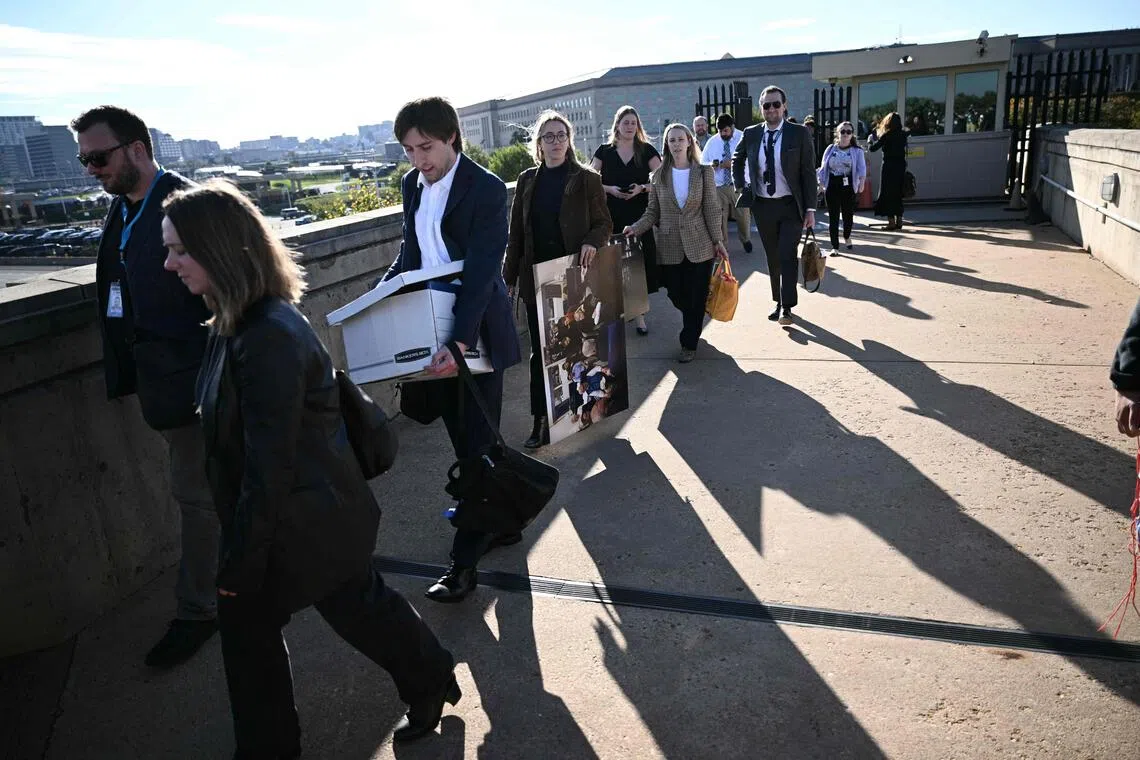 Reporters carry their belongings from the Pentagon on October 15, 2025, after news outlets declined to sign new media rules. PHOTO: AFP
