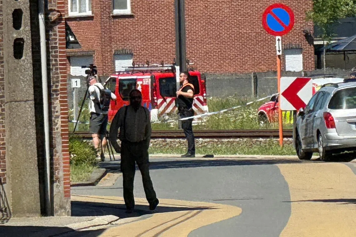 Emergency vehicles operate near the scene where a school bus was struck by a train at a level crossing leading to multiple casualities, near the town of Buggenhout, Belgium, May 26, 2026. REUTERS/Bart Biesemans
