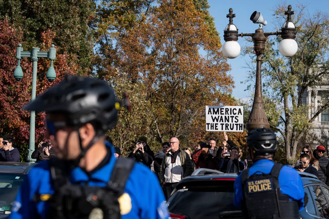 A protester holds a sign related to the release of the Jeffrey Epstein case files outside the US Capitol on Nov 12.
