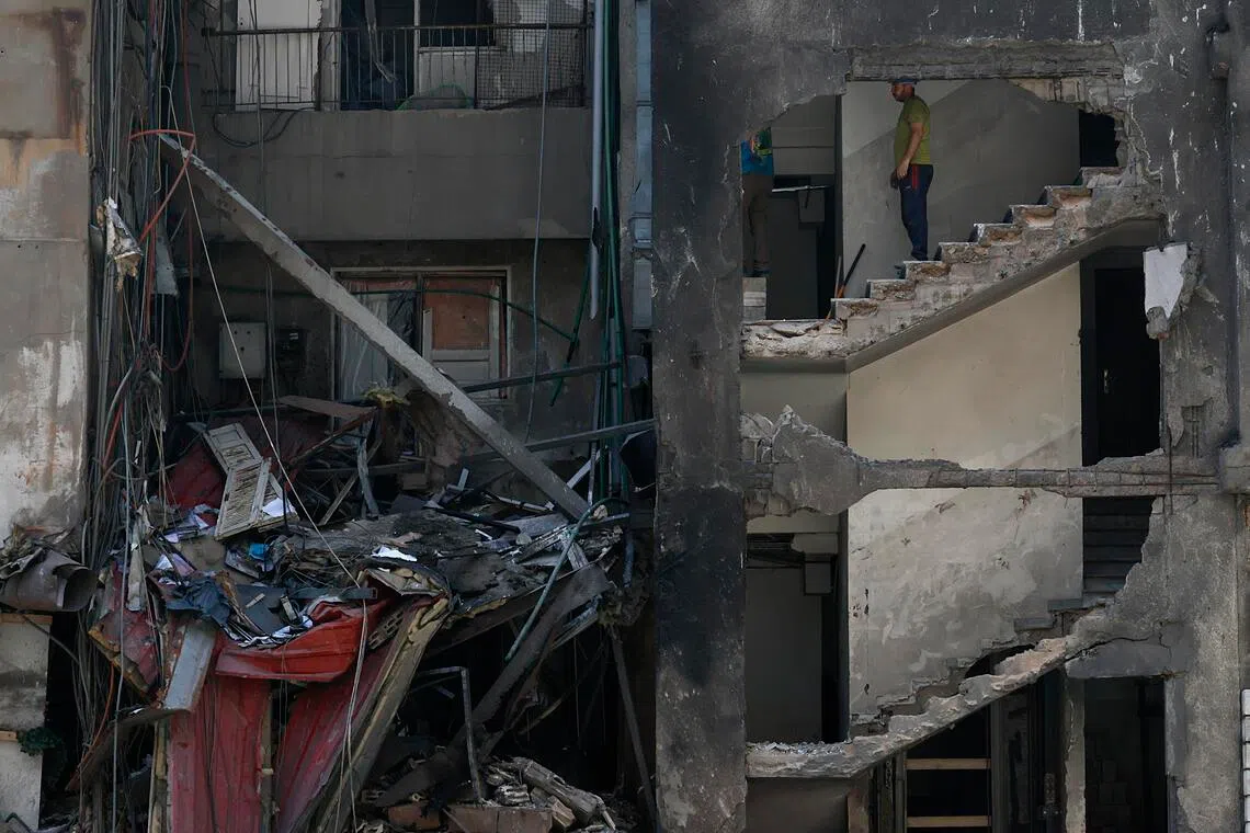 Workers stand inside a partially destroyed building in Corniche el Mazraa, in Beirut, Lebanon, on April 13, 2026.