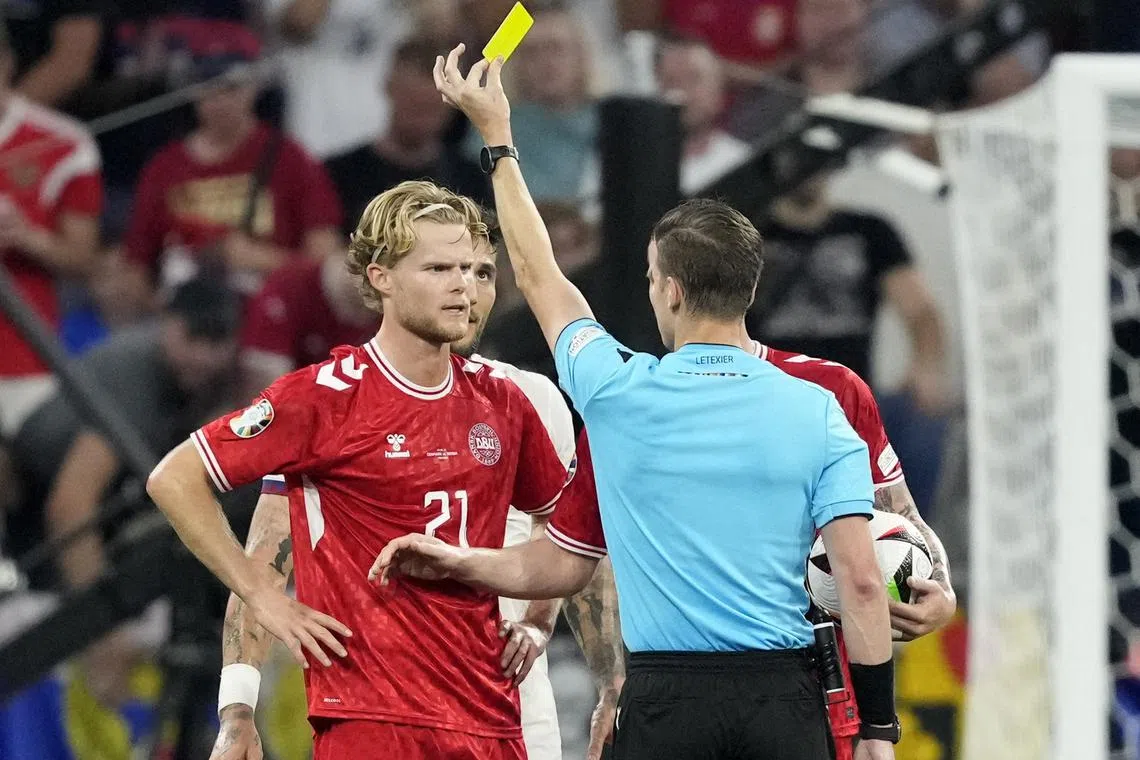 Soccer Football - Euro 2024 - Group D - Denmark v Serbia - Munich Football Arena, Munich, Germany - June 25, 2024 Denmark's Morten Hjulmand is shown a yellow card by referee Francois Letexier REUTERS/Fiona Noever