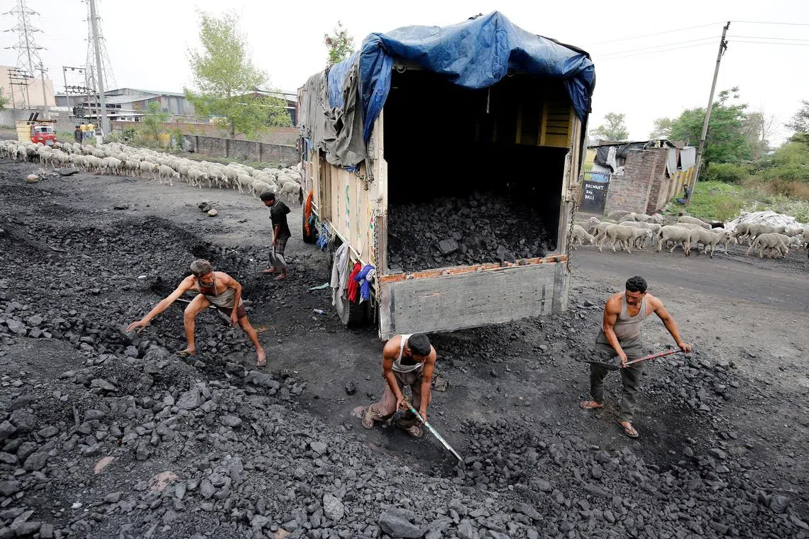 FILE PHOTO: Labourers load coal onto a supply truck on the outskirts of Jammu, April 6, 2017. REUTERS/Mukesh Gupta/File Photo