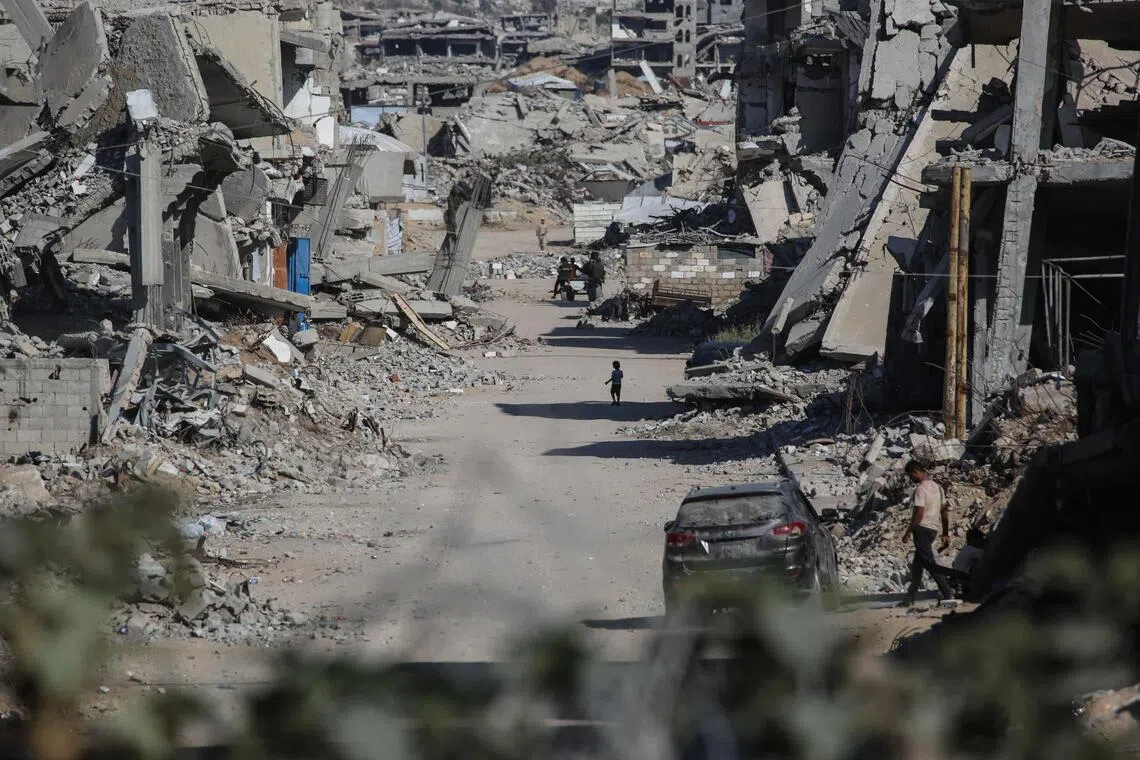 Palestinians making their way through destroyed buildings in Khan Yunis, in the southern Gaza Strip, on July 31.