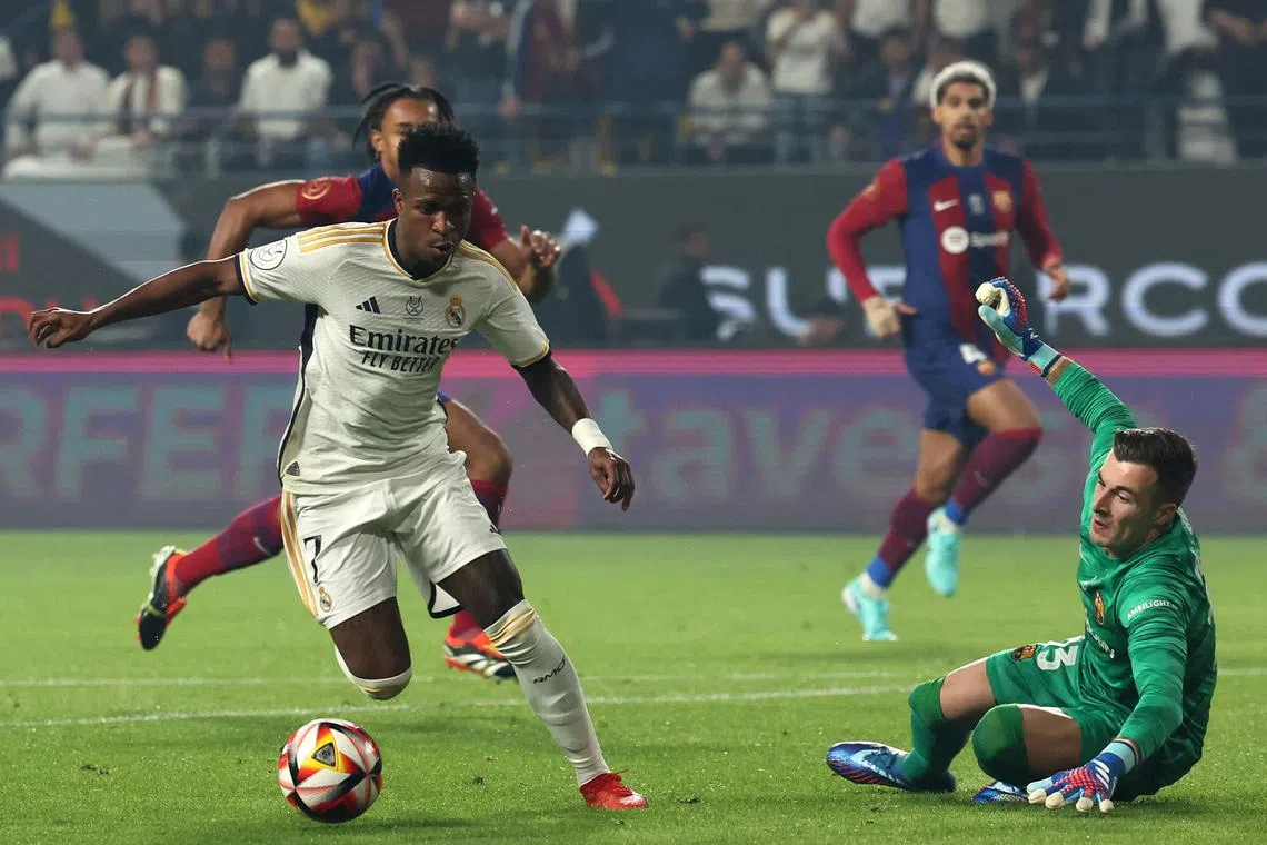 Real Madrid's Vinicius Junior running with the ball before scoring his second goal during the Spanish Super Cup final between Real Madrid and Barcelona at the Al-Awwal Park Stadium in Riyadh.