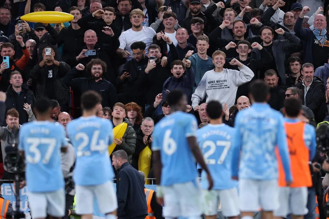 Manchester City players celebrating with fans after thrashing Liverpool 3-0 away in the English Premier League on Oct 11.