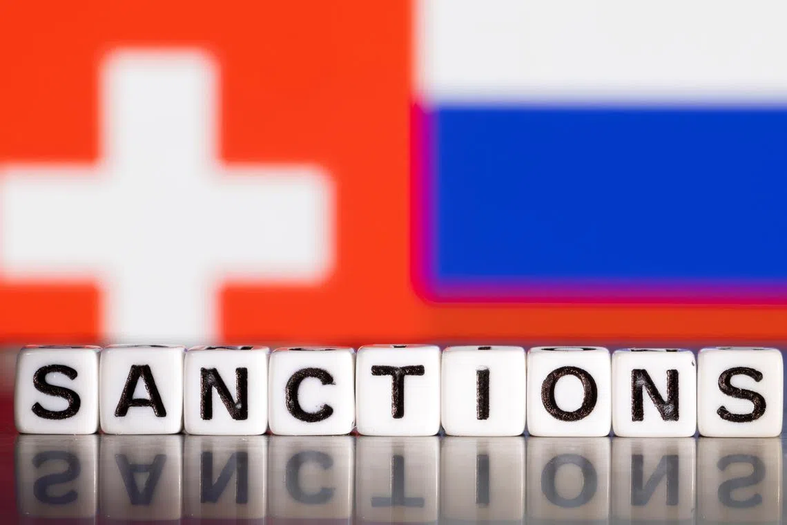 Plastic letters arranged to read \"Sanctions\" are placed in front flag colors of Switzerland and Russia in this illustration taken February 28, 2022. REUTERS/Dado Ruvic/Illustration/File Photo