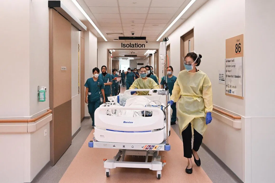 [For Yaohui's HIF on April 8, 2026] ST20251031-202570600550-Lim Yaohui-yhemergency/ A 'patient' codenamed Chuan Fa Sao being transferred by Senior Staff Nurse Naw Noreen and Dr Tang Shin Yee (foreground) to the medical intensive care unit (MICU) at Block 4 Level 5 of Singapore General Hospital after undergoing resuscitation at the isolation area in level 3 of the new SGH Emergency/NNI building on Oct 31, 2025. The patient has shortness of breath with fever and low oxygen saturation, displaying s