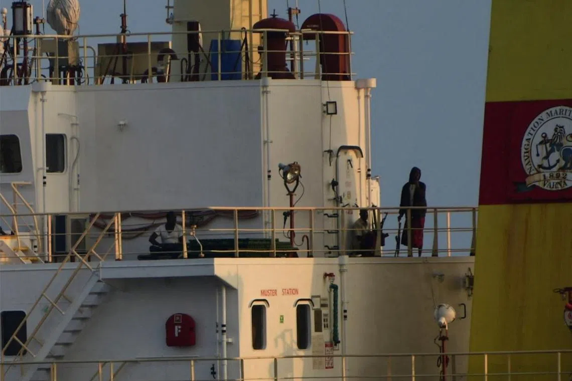 People with weapons stand onboard the Maltese-flagged bulk cargo vessel Ruen seized by Somali pirates, which was intercepted by the Indian Navy, at sea, in this handout photo released on March 16, 2024. SpokespersonNavy via X   /Handout via REUTERS
