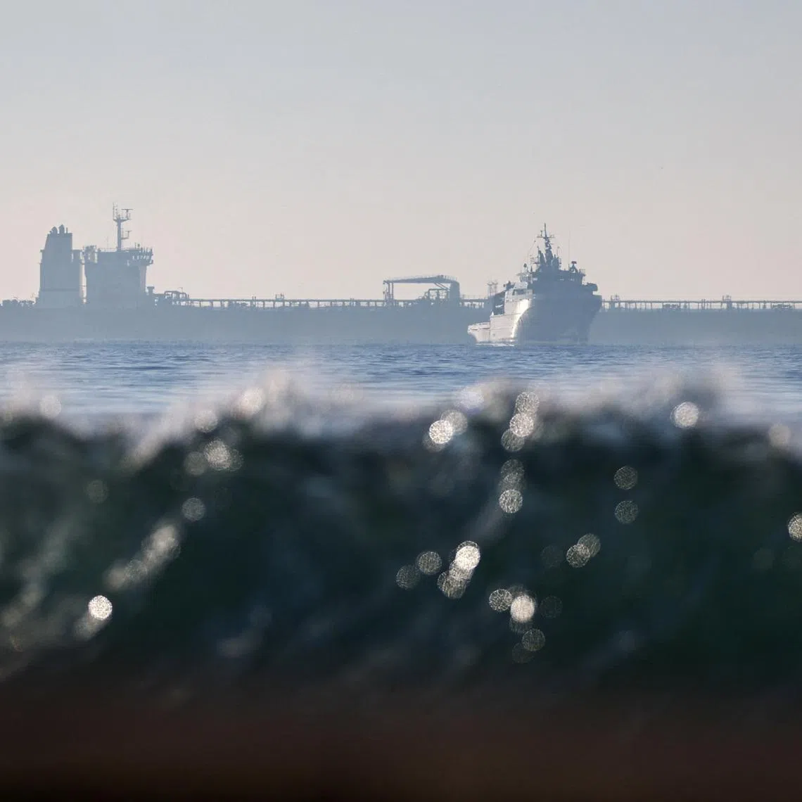 The silhouette of a French navy boat surrounding the GRINCH oil tanker, intercepted by France in the Alboran Sea on suspicion of operating under a false flag and belonging to Russia's shadow fleet that enables Russia to export oil despite sanctions, and diverted to the port of Marseille-Fos, in the Gulf of Fos-sur-Mer, near Martigues, France, January 25, 2026. REUTERS/Manon Cruz