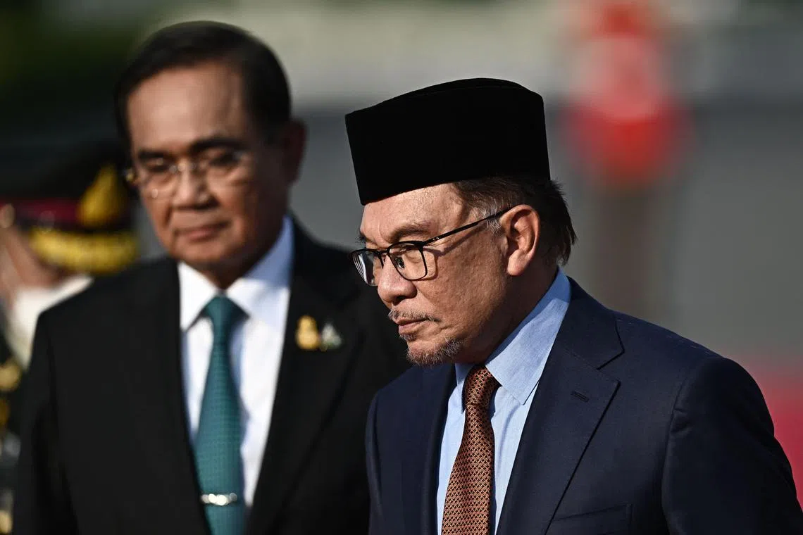 Thailand's Prime Minister Prayut Chan-O-Cha (left) and Malaysia's Prime Minister Anwar Ibrahim inspect a guard of honour during an official state visit at Government House in Bangkok, on Feb 9, 2023.