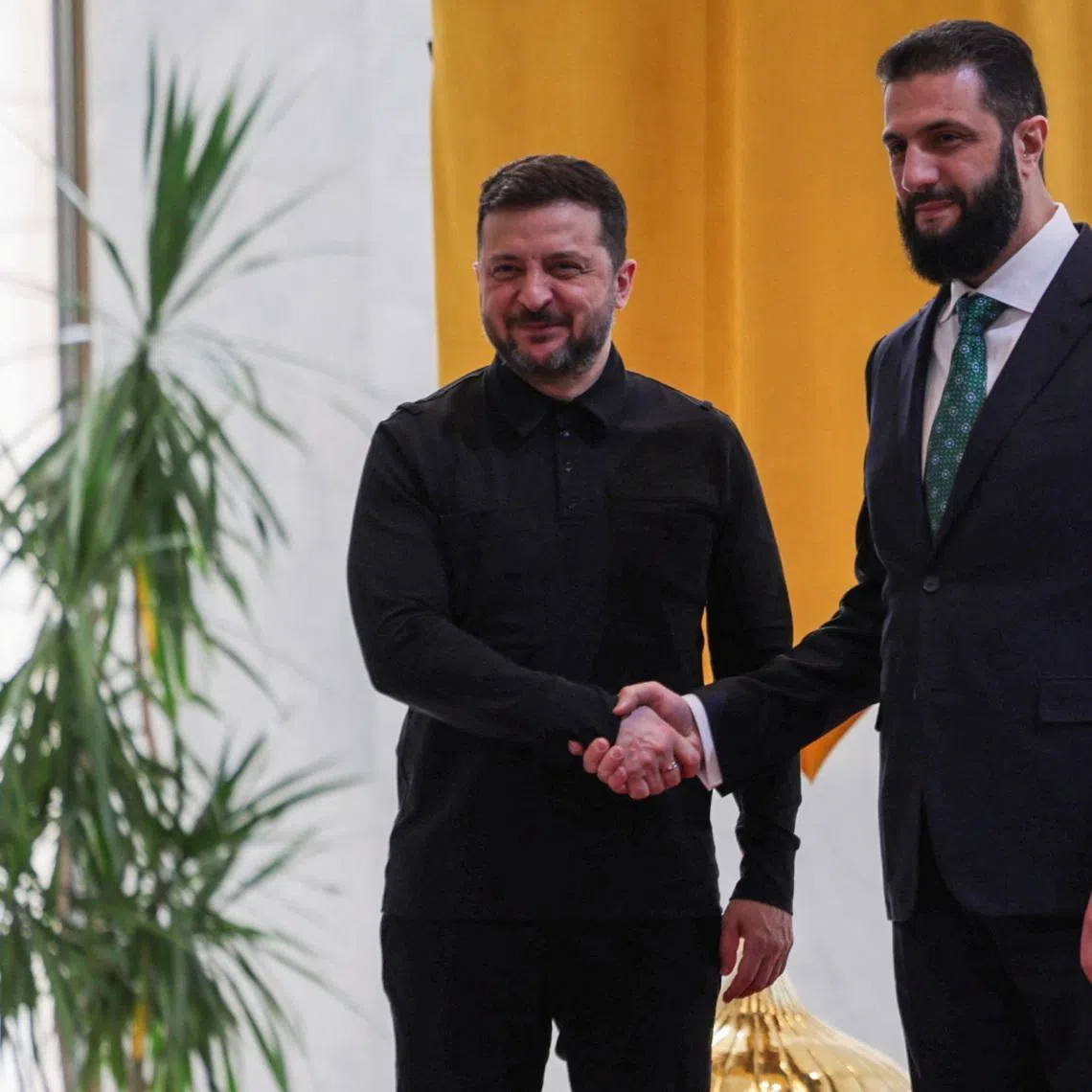 Ukraine's President Volodymyr Zelenskiy shakes hands with Syria's President Ahmed al-Sharaa as they meet in Damascus, Syria, April 5, 2026. REUTERS/Khalil Ashawi