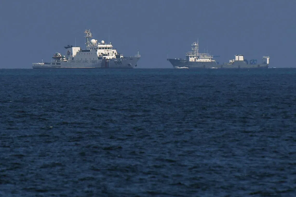 A Chinese coast guard vessel and a Chinese vessel sailing near the Philippine-occupied Thitu island in the disputed South China Sea on April 21.