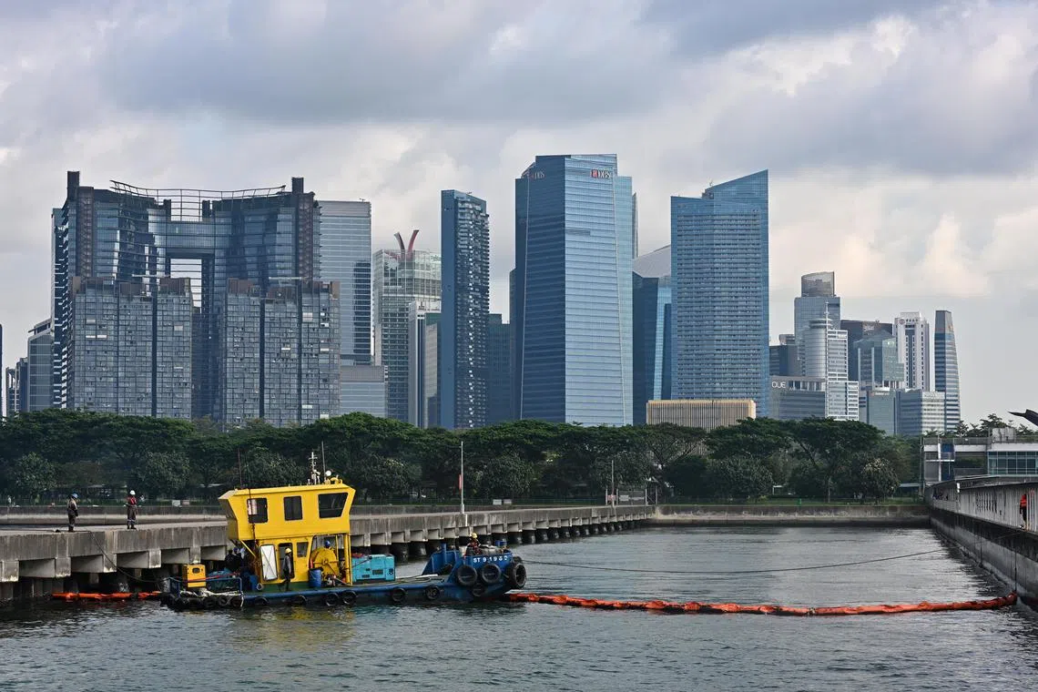 A skimmer craft at work lifting the oil off the water surface into storage tanks and containment booms to contain oil in water at Marina South Pier on June 18, 2024. Media tour by MPA to observe oil spill clean-up operations at sea which will include the use buster systems, skimmer craft, and containment booms on June 18, 2024. A drone will also be deployed as part of mitigation efforts.