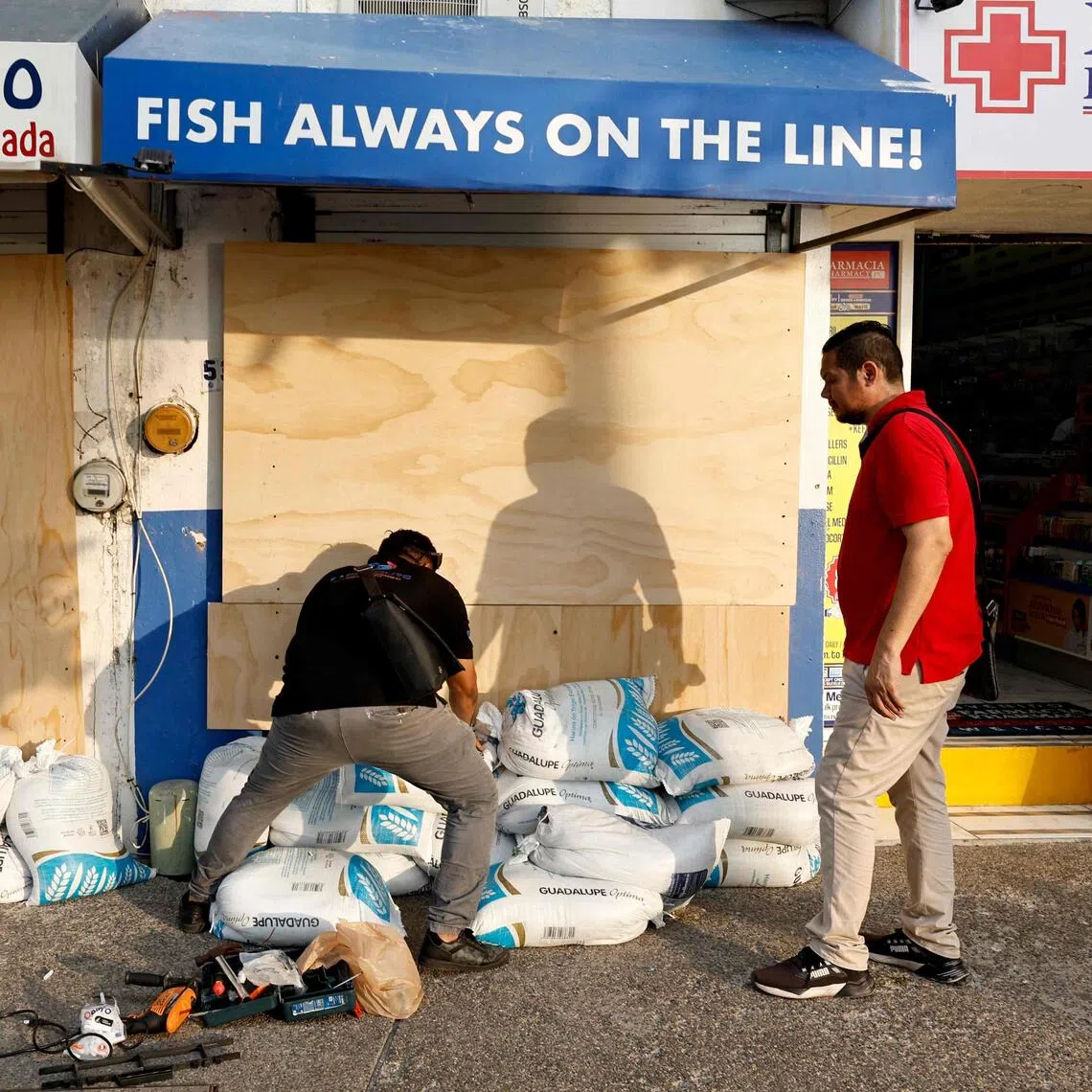 People in Puerto Vallarta, in Mexico’s Jalisco state, protecting their businesses from the potential impact of Hurricane Simon on Oct 9.