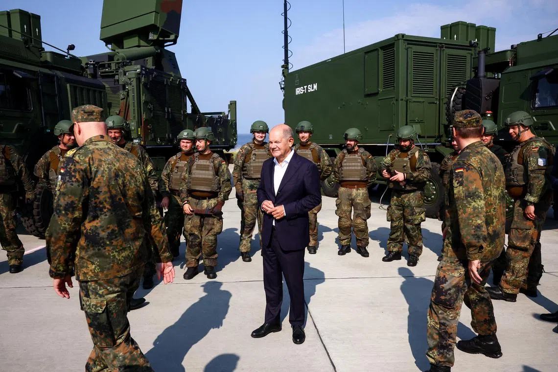 German Chancellor Olaf Scholz (centre) talking to German soliders during the ceremonial commissioning of a IRIS- T SLM air defence system, in Todendorf, northern Germany, on Sept 4.