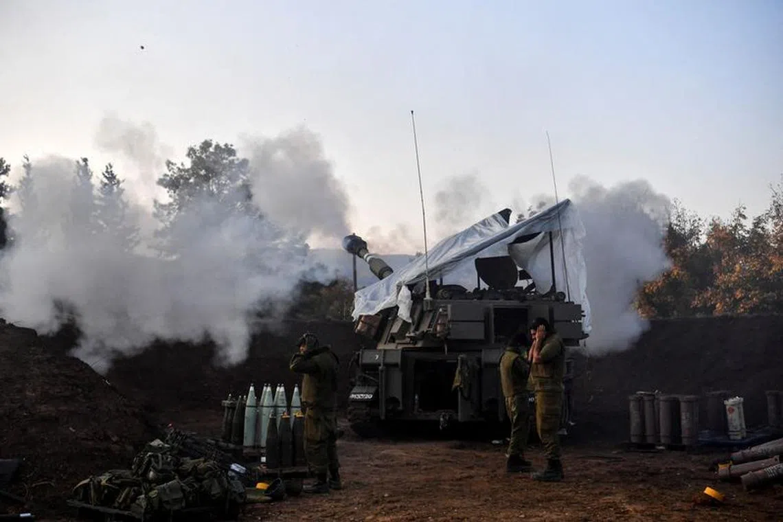 Israeli soldiers stand by, as a mobile artillery unit fires, on the Israeli side of the Israel-Lebanon border December 19, 2023 REUTERS/Gil Eliyahu/File Photo