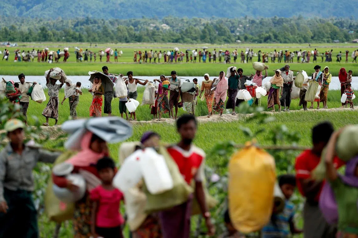Rohingya refugees who crossed the border from Myanmar walk to the refugee camps in Palang Khali, Bangladesh, on October 19, 2017. 