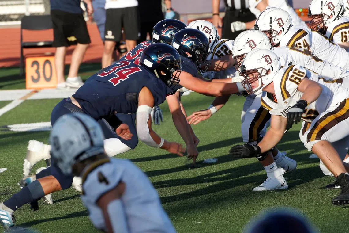 FILE PHOTO: Players from the Herriman Mustangs (L) and the Davis Darts (R) square off during a game between the two high school teams in this file photo in Utah, U.S. August 13, 2020. REUTERS/George Frey/File Photo