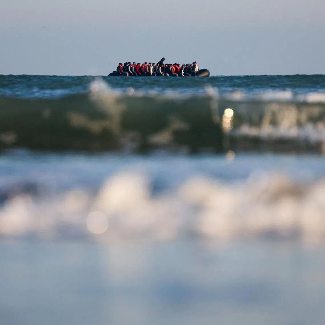 Migrants on an inflatable dinghy leave the coast of northern France in an attempt to cross the English Channel to reach Britain, from the beach of Petit-Fort-Philippe in Gravelines, near Calais, France, September 27, 2025. REUTERS/Abdul Saboor/File Photo