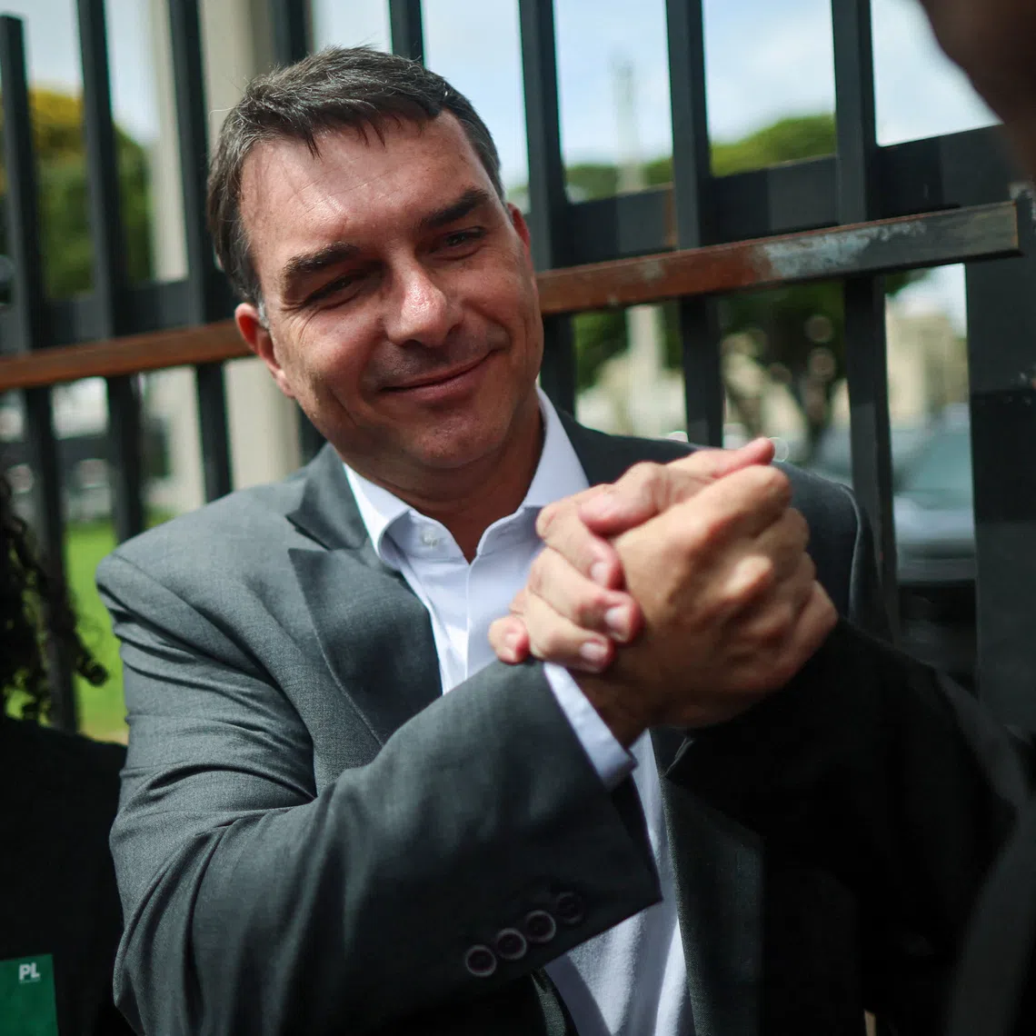 Senator Flavio Bolsonaro, Brazil's former President Jair Bolsonaro's son, greets supporters after visiting his father at a Federal Police building in Brasilia, Brazil, December 9, 2025. REUTERS/Adriano Machado