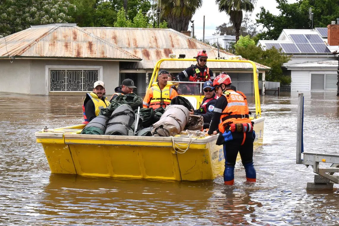 State Emergency Service (SES) personnel navigate floodwaters with residents and supplies aboard a watercraft at the town of Forbes, in the Central West region of New South Wales, Australia, Nov 16, 2022. 
