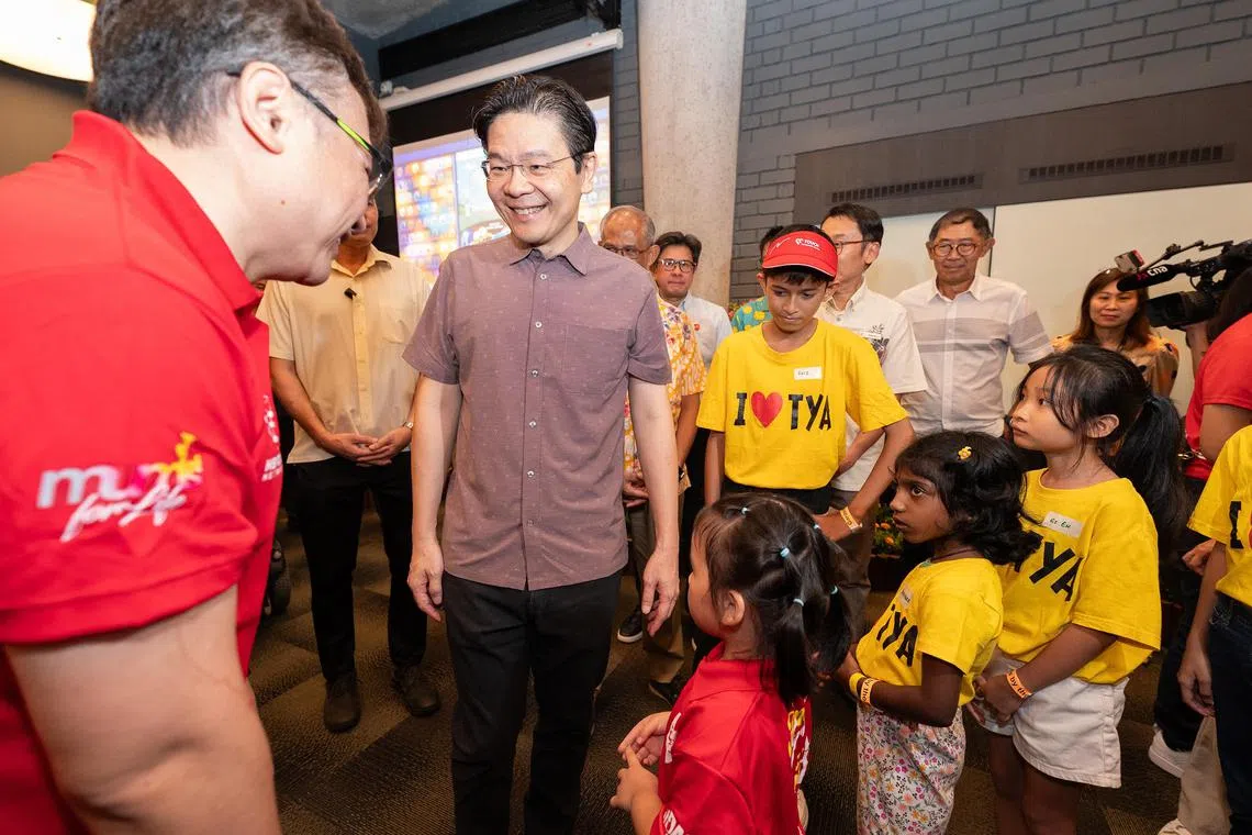 myfamfest - Prime Minister Lawrence Wong interacting with Mr Wong Yie Chuen Alex, 50 years old, Volunteer at Families for Life, and his daughter Wong Ru Yee (both in red), 5 years old, at the launch of the National Family Festival at Gardens by the Bay on 25 May 2024.

ST PHOTO: Brian Teo
