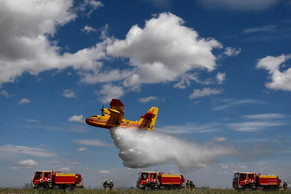 A Canadair water bomber spraying water during a demonstration of civil security forest firefighting equipment at their base the airport of Nimes-Garons, southern France, on April 25, 2023. 