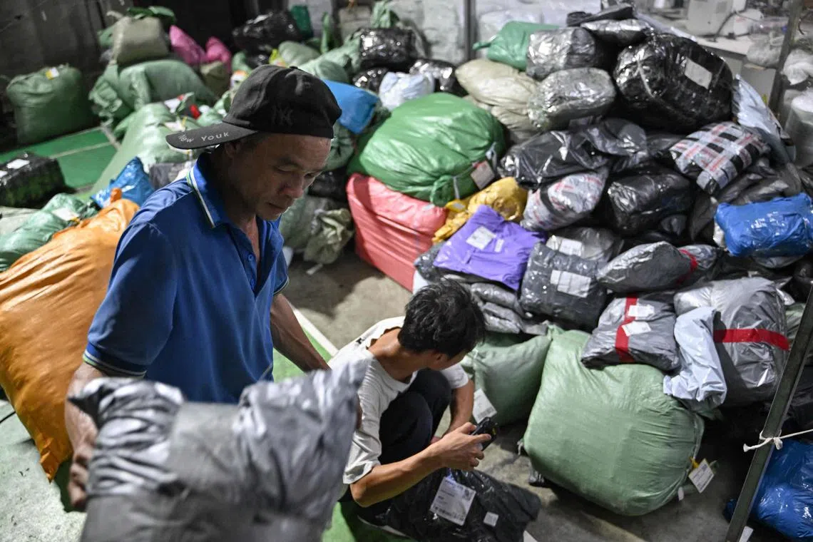 Workers at a delivery company in Guangzhou sort out packages of online shopping giant.