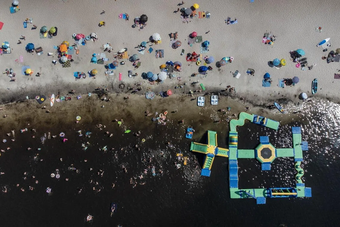 epa13071006 People swim and sunbathe at Lake Piaseczno, in Leczna-Wlodawa Lake District, about 43 km northeast of the city of Lublin, Poland, 28 June 2026. Poland's Institute of Meteorology and Water Management (IMGW) has issued Level 3 extreme heat warnings for most of the country, as temperatures are expected to reach up to 42 degrees Celsius. EPA/WOJTEK JARGILO POLAND OUT